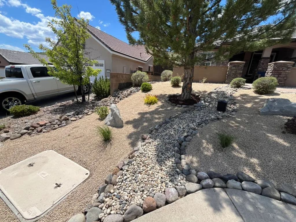 Desert landscape design with gravel, rocks, and shrubs in a residential front yard.